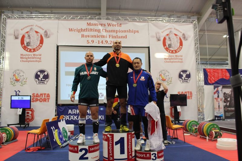 Omar Khathiri bovenaan het podium met een gouden medaille bij het wereldkampioenschap Masters in Rovaniemi, Finland.