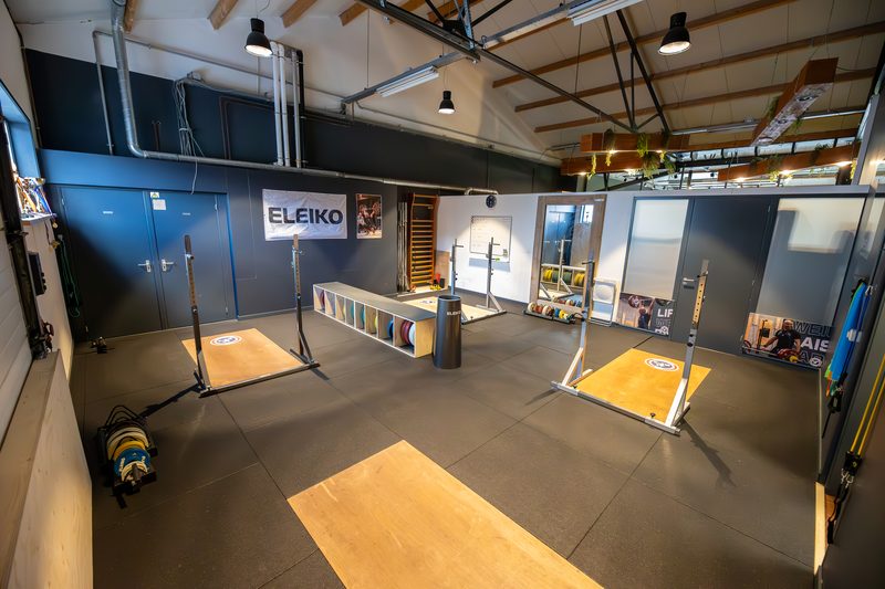 De zaal van Weightlifting Club Hoorn met twee heftplatforms, halterstangen en Eleiko-materiaal.